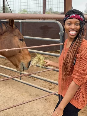 woman feeding horse at restoration ranch