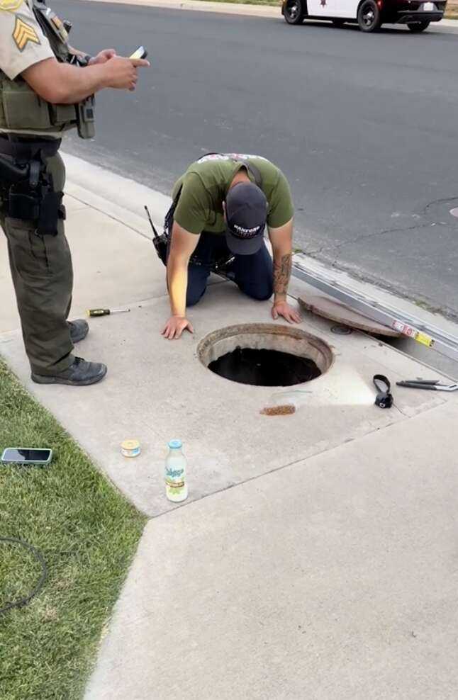 Firefighter looking down into rain gutter